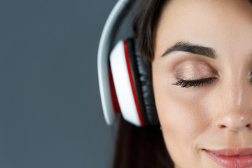 Beautiful dark haired smiling woman wearing headphones