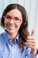 Support phone operator in headset showing thumbs up