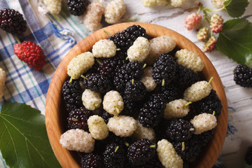 White and black mulberries in bowl closeup. horizontal top view

