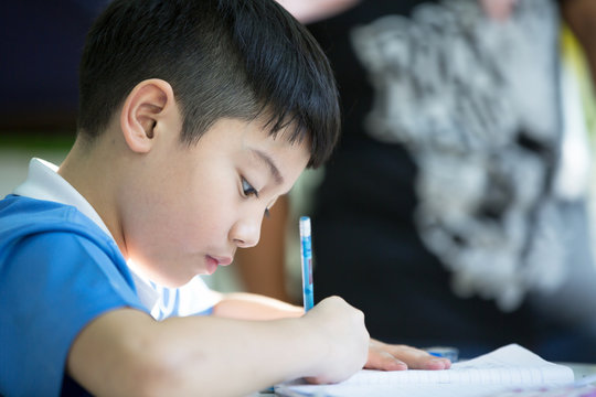 Young asian boy doing his homework