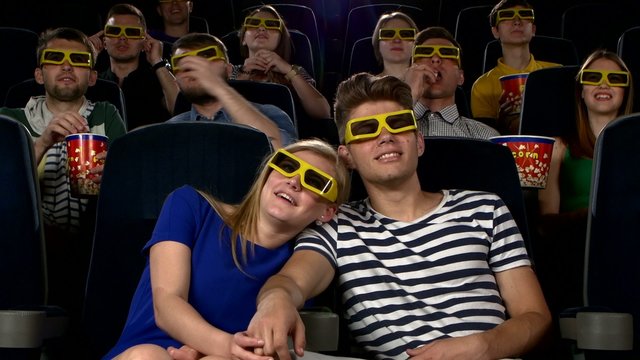 Couple in cinema watching a movie with 3D glasses
