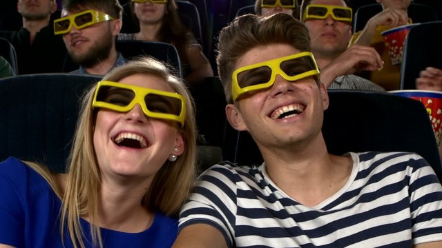 Couple in cinema watching a movie with 3D glasses. Close Up