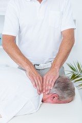 Obraz na płótnie Canvas Physiotherapist doing neck massage to his patient