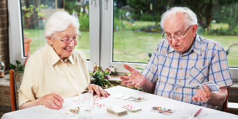 Elderly couple playing cards