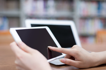 Asian beautiful female student using tablet in library