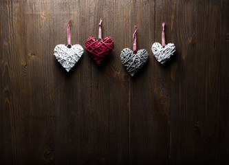 Red hearts hanging over old wood background