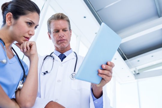 Serious doctors looking at clipboard