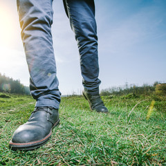 man walking on a meadow wearing boots