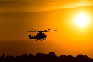 Obraz na płótnie Canvas silhouette of military helicopter at sunset