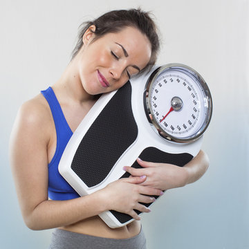 satisfied young woman in love with her weight scale