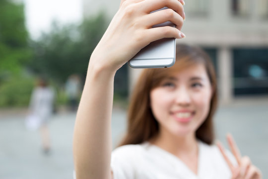 asian beautiful young woman using mobile phone to take selfie ou