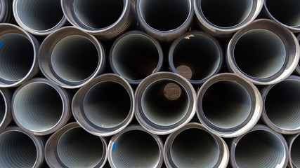 Black sewer pipes stacked, ready for undergrounding