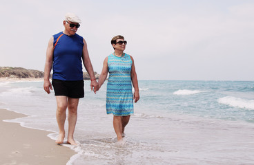 senior couple walking on the beach