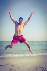 Obraz premium Happy man jumping on the beach