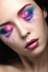 Beautiful girl with bright pink make-up and perfect skin. Beauty face. Festive image. Picture taken in the studio on a gray background.