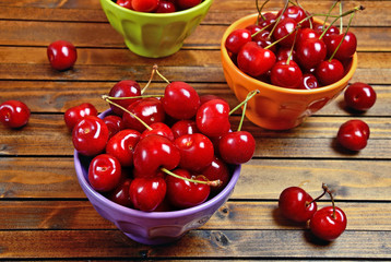 Colorful bowl with cherries on table