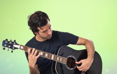 Obraz premium Handsome man with guitar over white background