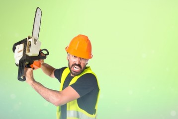 Workman with chainsaw over white background