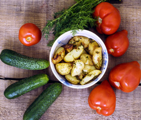 homemade food, fried potatoes, tomatoes, cucumbers and fennel on wooden table