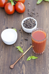 Tomato juice, tomatos, herbs and spices on wooden table