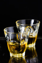 Two glasses of whiskey with ice cubes