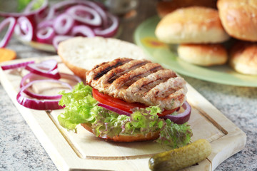Homemade burgers with green salad, tomato, red onion, chicken, p