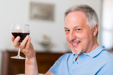 Mature man enjoying a glass of red wine