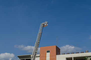 Obraz premium Fire truck ladder against blue sky