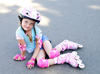 Cute smiling little girl in pink roller skates