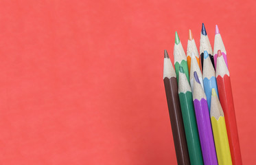 Colored pencils on red background.