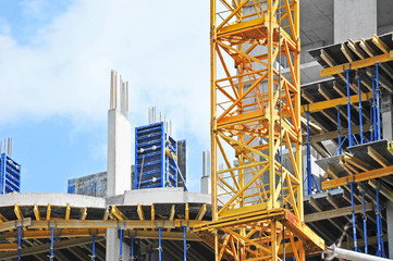 Crane and building construction site against blue sky
