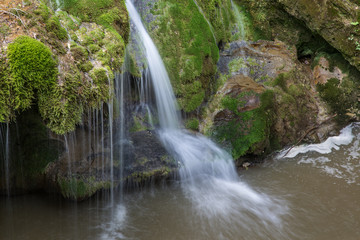 Wild natural waterfall in a deep mountain forest