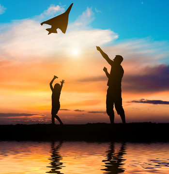 Dad And Daughter Flying A Kite On The Beach