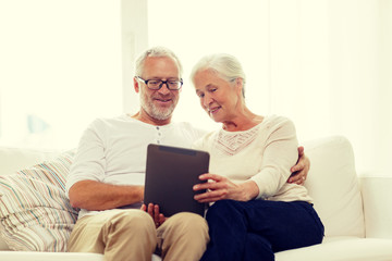 happy senior couple with tablet pc at home