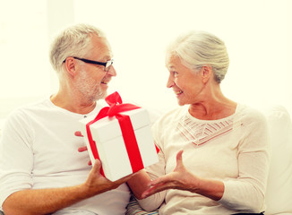 happy senior couple with gift box at home