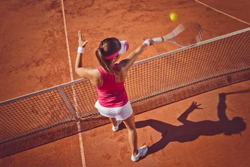 Tuinposter Young woman playing tennis.High angle view.Forehand volley. © BalanceFormCreative