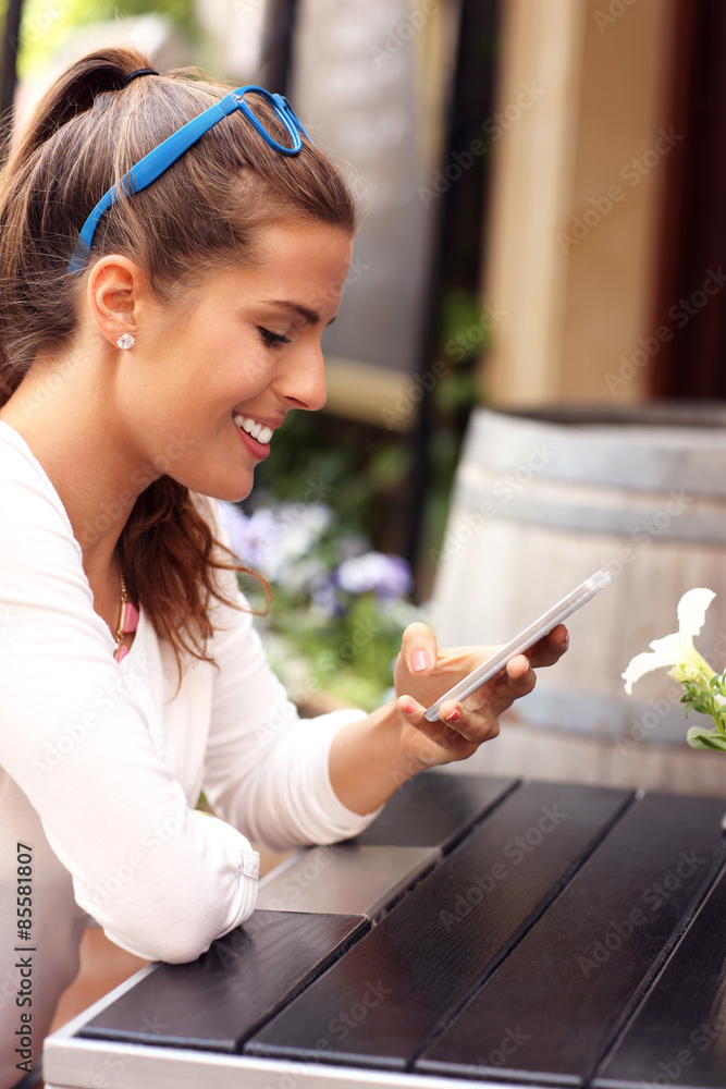 Poster Happy woman using smartphone in cafe