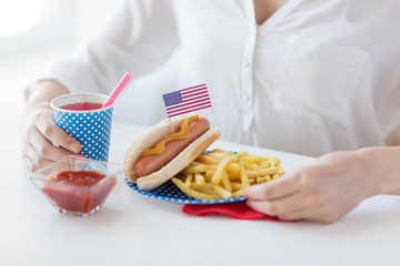 close up of woman eating hotdog and french fries