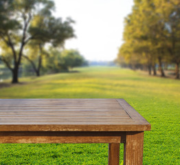 Fototapeta premium empty free space top wood table on green grass field against sun
