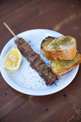 meat skewers (souvlaki) with lemon and bread, Greek traditional cuisine