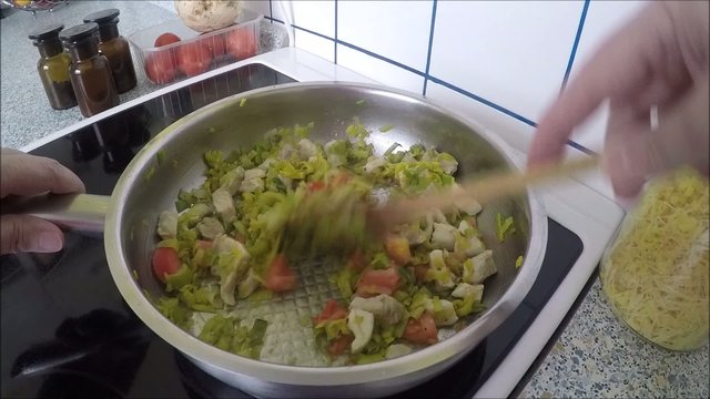 Hands cooking vegetable ragout in pan in kitchen
