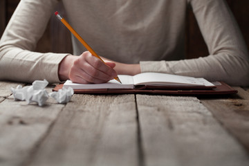 hand writes with a pen in a notebook