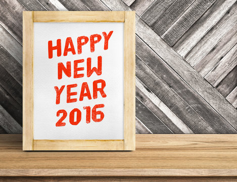 Happy New Year 2016 word on wood frame on table and diagonal pla