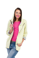 Smiling young woman posing in hoodie and looking away. Three quarter length studio shot isolated on white.