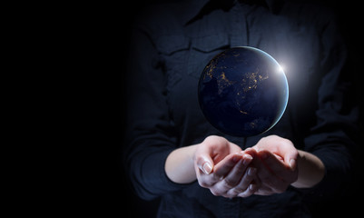 Businesswoman holding Earth planet in palm. Elements of this image are furnished by NASA