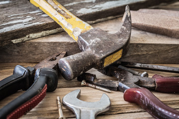 Dirty set of hand tools on a wooden panel