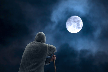climber Man contemplating the big white moon at night