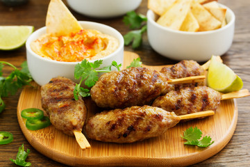 Kyufta (barbecue) of lamb with snacks (radish salad, chips and hummus.)