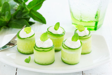 Rolls of cucumber with curd cheese and yogurt with mint.