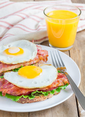 Open face sandwich with egg, bacon, tomato and lettuce